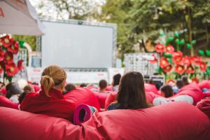 people at city public park watching movie at open air cinema. romantic date