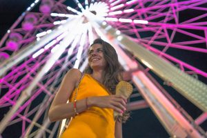 Beautiful brunette woman at amusement park in the night