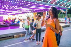 Beautiful brunette woman at amusement park in the night